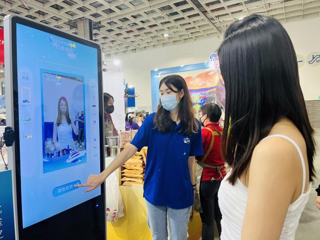1111104 民眾在 ITF台北國際旅展金門館拍照並掃描QRcode下載藍色公路照片。
