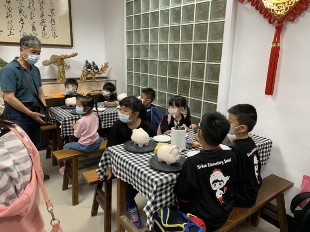 1100507烈嶼西口國小師生蒞臨金門縣陶瓷廠參觀體驗DIY彩繪小豬活動，圖為小學生聆聽講解專注的模樣。